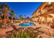 Twilight shot of the backyard showcasing a pool, hot tub, covered bar, lounge chairs, and manicured landscaping at 5805 Cabo San Lucas Ave, Las Vegas, NV 89131