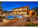 Backyard at dusk featuring a luxurious pool, hot tub, covered patio bar, and lush tropical landscaping, ideal for relaxation at 5805 Cabo San Lucas Ave, Las Vegas, NV 89131