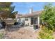 View of backyard with patio area, gravel ground, and mature trees at 5914 Rose Sage St, North Las Vegas, NV 89031