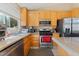 Bright kitchen features wooden cabinets, stainless steel appliances, and granite countertops at 5914 Rose Sage St, North Las Vegas, NV 89031