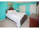 Bedroom with bright teal walls, matching wood furniture, and a comfortable bed at 6249 Halehaven Dr, Las Vegas, NV 89110