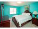 Bedroom with bright teal walls, matching wood furniture, and a comfortable bed with a decorative painting at 6249 Halehaven Dr, Las Vegas, NV 89110