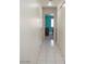 Hallway featuring clean white tile and leading to a bright bedroom with its own interior decoration at 6249 Halehaven Dr, Las Vegas, NV 89110