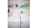 Efficient laundry room with front-load washer and dryer, complemented by overhead storage shelves for supplies at 6249 Halehaven Dr, Las Vegas, NV 89110