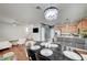 Open dining area featuring a stylish chandelier, kitchen bar, and views to the living room at 635 Taliput Palm Pl, Henderson, NV 89011