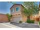 Inviting two-story home with a two-car garage, desert landscaping, and a charming facade at 635 Taliput Palm Pl, Henderson, NV 89011