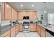 Well-equipped kitchen with stainless steel appliances, light wood cabinets, and granite counters at 635 Taliput Palm Pl, Henderson, NV 89011