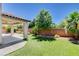 Backyard featuring a covered patio, paver patio, brick wall, and manicured lawn at 6569 Cedar Waxwing St, North Las Vegas, NV 89084