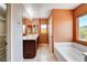Bathroom showcasing double sinks, a soaking tub, and a large window for natural lighting at 6569 Cedar Waxwing St, North Las Vegas, NV 89084