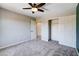 Bedroom with gray carpet, ceiling fan, closet doors, and doorways at 6569 Cedar Waxwing St, North Las Vegas, NV 89084