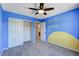 Blue bedroom featuring 'You are my sunshine' wall art, ceiling fan, and closet doors at 6569 Cedar Waxwing St, North Las Vegas, NV 89084