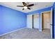 Blue bedroom with closet, ceiling fan, gray carpet and doorway at 6569 Cedar Waxwing St, North Las Vegas, NV 89084