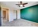 Bedroom featuring a dark accent wall, gray carpet, ceiling fan, and closet doors at 6569 Cedar Waxwing St, North Las Vegas, NV 89084
