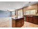 Modern kitchen island with dark wood cabinets and granite countertop overlooking the living area at 6569 Cedar Waxwing St, North Las Vegas, NV 89084