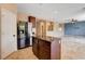 Modern kitchen island with dark wood cabinets, stainless steel refrigerator and appliances at 6569 Cedar Waxwing St, North Las Vegas, NV 89084