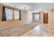 Open living room area with carpet and tile flooring, bright light from windows, and an entry door at 6569 Cedar Waxwing St, North Las Vegas, NV 89084