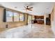 Open-concept living space with tiled floors, ceiling fan, and sliding glass door to backyard at 6569 Cedar Waxwing St, North Las Vegas, NV 89084
