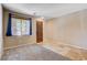 Inviting living room with carpet and tile flooring, a classic wooden door, and a window that lets in natural light at 6569 Cedar Waxwing St, North Las Vegas, NV 89084