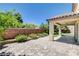 Paver patio with covered area, brick wall, and lush landscaping at 6569 Cedar Waxwing St, North Las Vegas, NV 89084