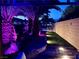 Backyard featuring stone pavers, turf, a hot tub, and purple up-lighting at 6614 Collingsworth St, Las Vegas, NV 89131