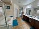 Bright bathroom with double vanities, a walk-in shower, and separate soaking tub with tile flooring at 6614 Collingsworth St, Las Vegas, NV 89131