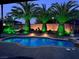 Backyard pool and landscaped area with palm trees illuminated with green lighting at 6614 Collingsworth St, Las Vegas, NV 89131
