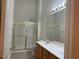 Bathroom with a double vanity, a large mirror, and a glass-enclosed shower with gold trim at 700 Carnegie St # 4821, Henderson, NV 89052