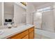 Bathroom features a shower-tub combo with glass doors, and a wood vanity at 825 W Ryan Ave, Overton, NV 89040