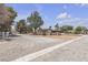 Inviting property entrance with a gravel driveway leading to a beautiful home surrounded by desert flora and trees at 825 W Ryan Ave, Overton, NV 89040