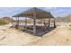 A metal horse shelter with pipe fencing provides shade and safety in a desert landscape at 825 W Ryan Ave, Overton, NV 89040