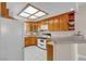 Cozy kitchen with wooden cabinets, white appliances, and a bright, natural light skylight at 825 W Ryan Ave, Overton, NV 89040