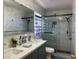 Bright bathroom with double sinks, white marble walls, and a glass-enclosed shower at 8901 Kingswood Dr, Las Vegas, NV 89147