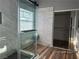 Modern bathroom featuring a walk-in glass shower, marble-style wall tiles, and wooden floors at 8901 Kingswood Dr, Las Vegas, NV 89147