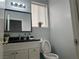 Clean half bathroom with a white vanity, black countertop, and minimalist design at 8901 Kingswood Dr, Las Vegas, NV 89147