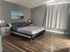 This bedroom boasts wood floors, grey walls, and a modern black and white bed frame for a stylish and comfortable living space at 8901 Kingswood Dr, Las Vegas, NV 89147