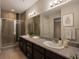 Bathroom features a modern double sink vanity with a large mirror and tiled shower at 9015 Chopper Prairie St, Las Vegas, NV 89131