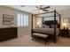 Comfortable bedroom featuring a four-poster bed, dresser, bench, and plenty of natural light at 9015 Chopper Prairie St, Las Vegas, NV 89131