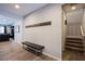 Hallway with a bench and coat rack, leading to the living room and staircase at 9015 Chopper Prairie St, Las Vegas, NV 89131