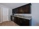 Kitchenette featuring modern dark cabinets, granite countertops, and stainless steel appliances at 9015 Chopper Prairie St, Las Vegas, NV 89131
