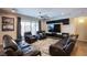 Comfortable living room with leather seating, ceiling fan, and sliding glass door to the backyard at 9015 Chopper Prairie St, Las Vegas, NV 89131