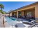 Relaxing backyard featuring a pool with lounge chairs and a covered patio seating area at 9015 Chopper Prairie St, Las Vegas, NV 89131