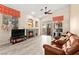 Inviting living room featuring a cozy fireplace, ceiling fan, and sliding glass doors to backyard at 9733 Northern Dancer Dr, Las Vegas, NV 89117