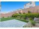 Landscaped backyard features a small lawn and stone patio with privacy wall at 10347 Restless River St, Las Vegas, NV 89141