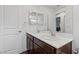 Bathroom featuring a double sink vanity with dark cabinets and a large mirror at 10347 Restless River St, Las Vegas, NV 89141