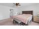 Bright bedroom with a ceiling fan, carpet flooring, and a door to another room at 10347 Restless River St, Las Vegas, NV 89141
