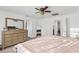 Light-filled bedroom boasts a ceiling fan, large mirror, dresser, and plush carpet at 10347 Restless River St, Las Vegas, NV 89141