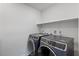 Laundry room with new washer and dryer units plus a shelf at 10347 Restless River St, Las Vegas, NV 89141