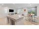 Open concept living room and dining area with a large island and access to backyard at 10347 Restless River St, Las Vegas, NV 89141