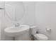 Clean and modern powder room with pedestal sink and efficient toilet at 10347 Restless River St, Las Vegas, NV 89141