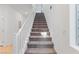 Carpeted staircase with white railing leading to the upper level of the home at 10347 Restless River St, Las Vegas, NV 89141
